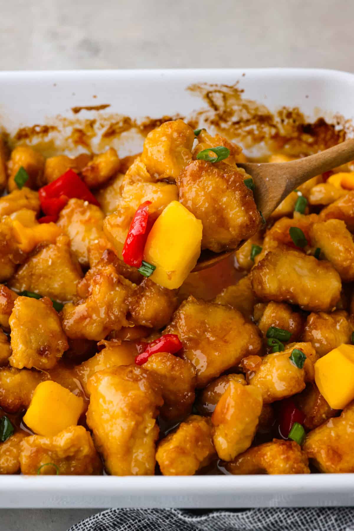 Closeup of chicken topped with mango and chopped red bell peppers.