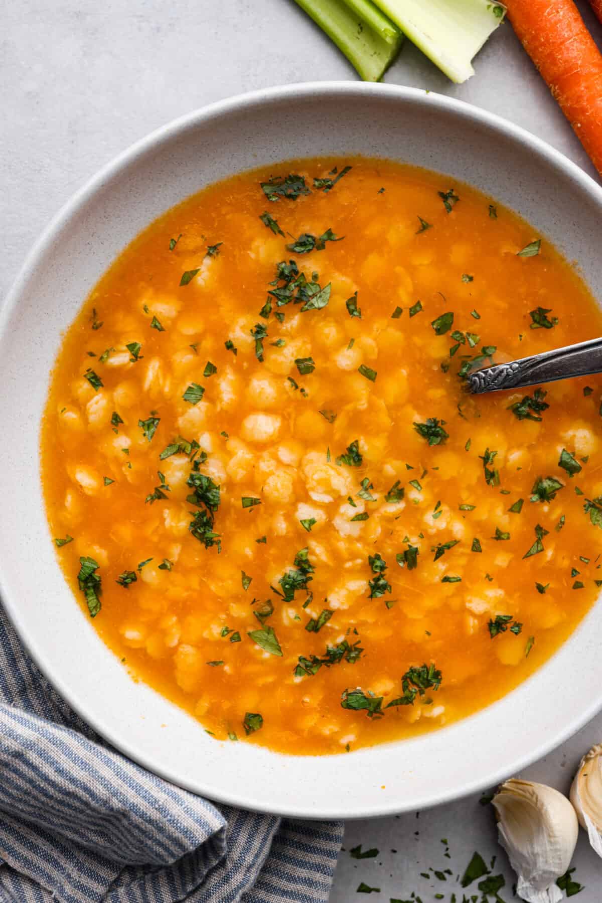 A serving of soup in a white bowl.