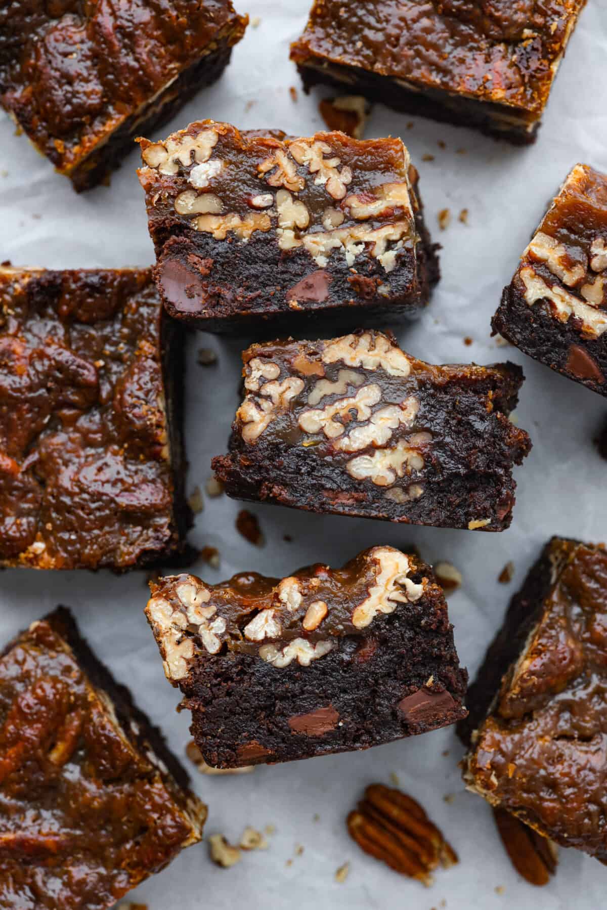 Overhead shot of pecan pie brownies cut into squares, some on their sides. 