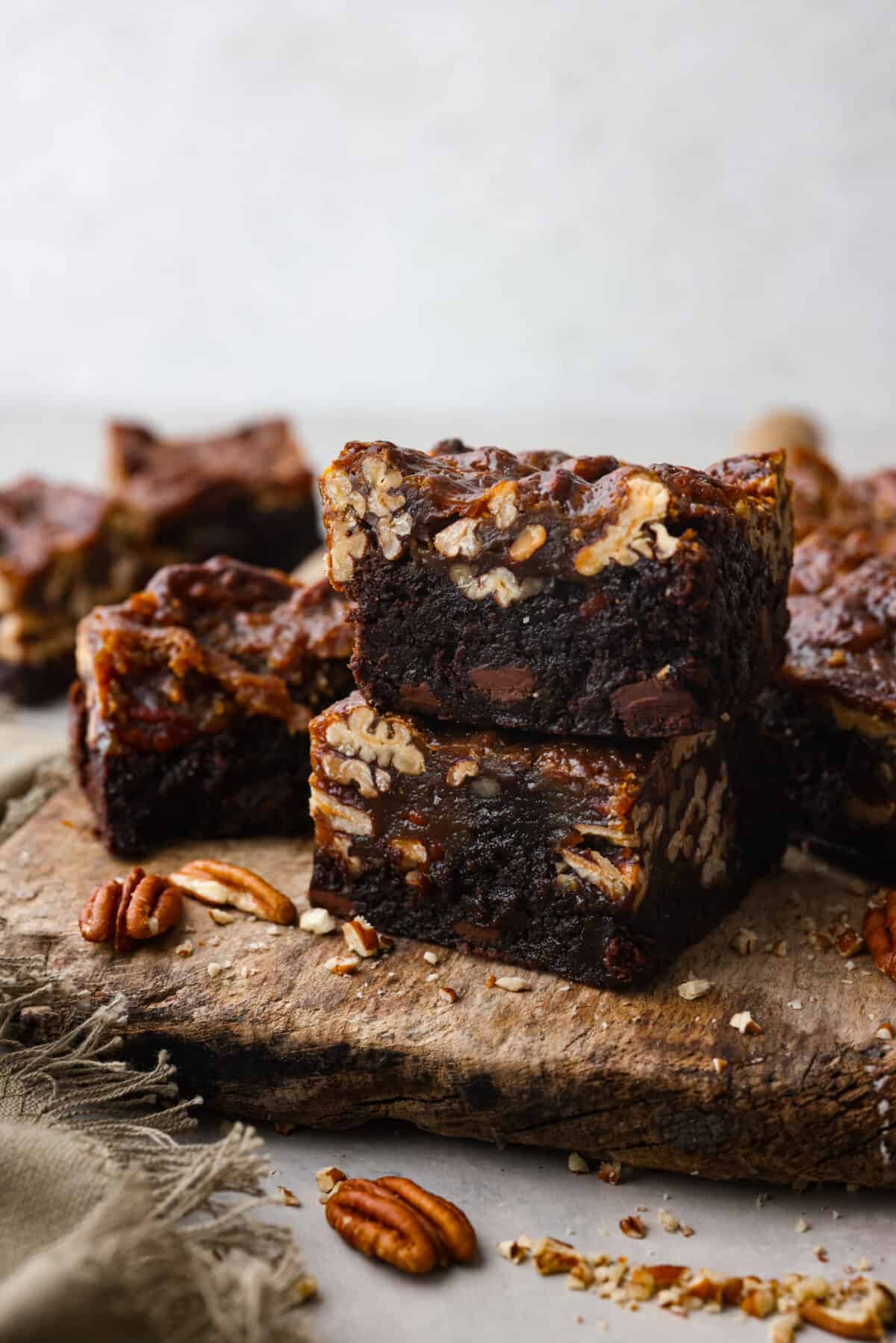 Two brownies stacked on top of each other on a serving board.