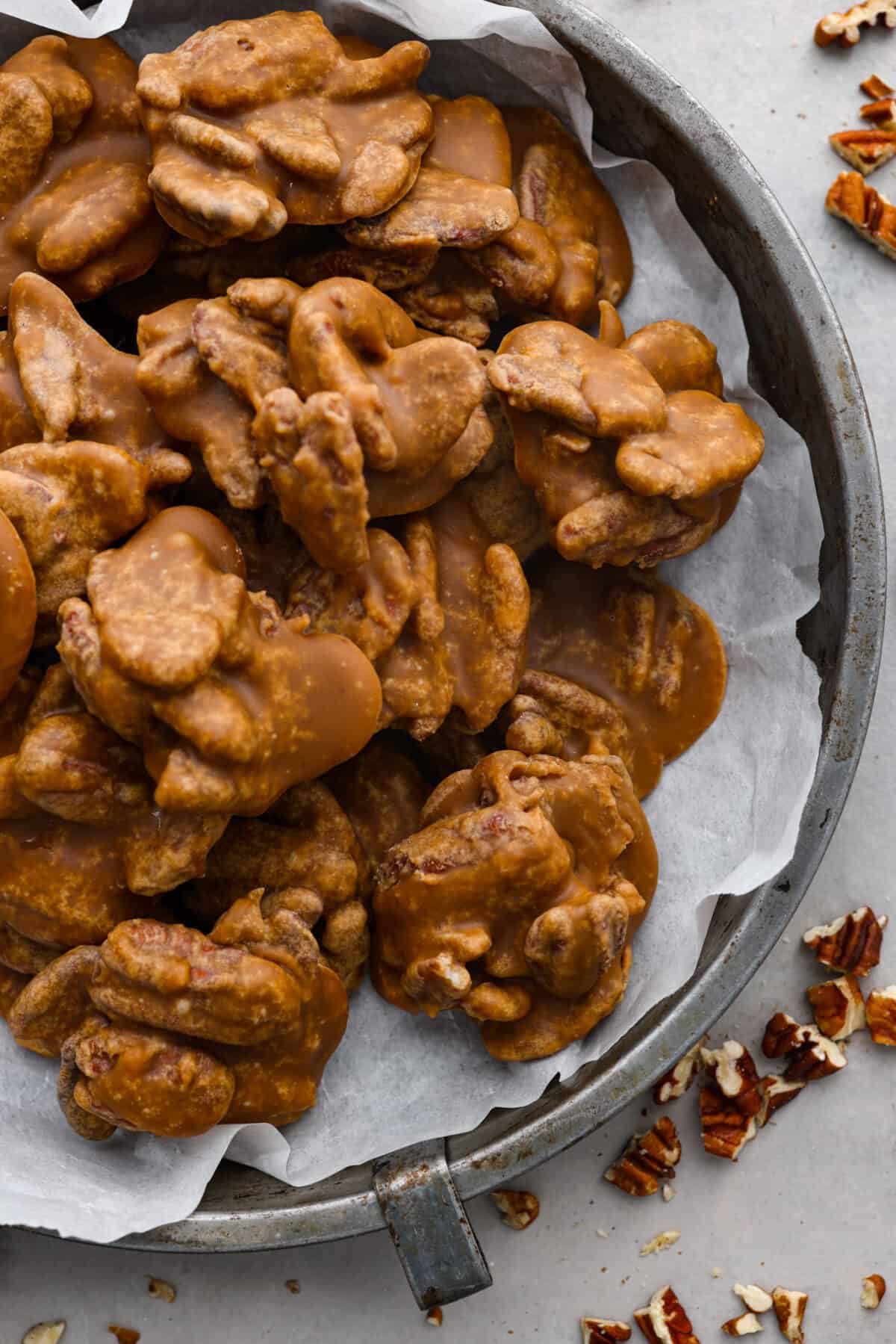 The top view of pralines in a tin pan with some parchment paper. 