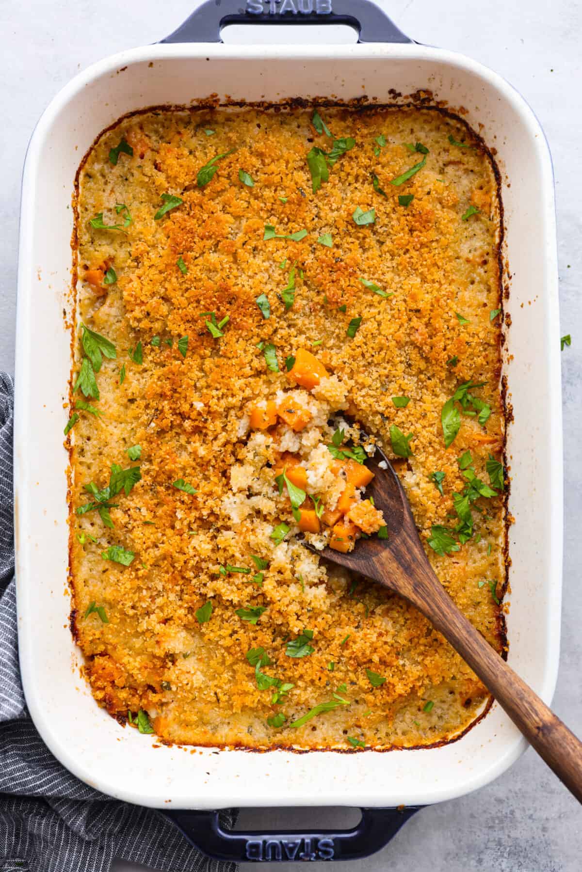 Top-down view of savory sweet potato casserole in a white baking dish.