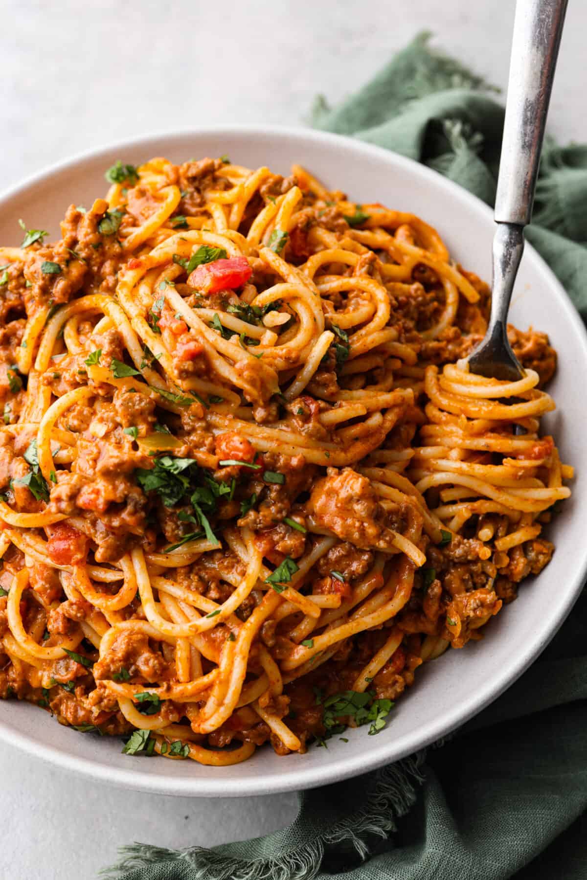 A serving of taco spaghetti, topped with fresh herbs.