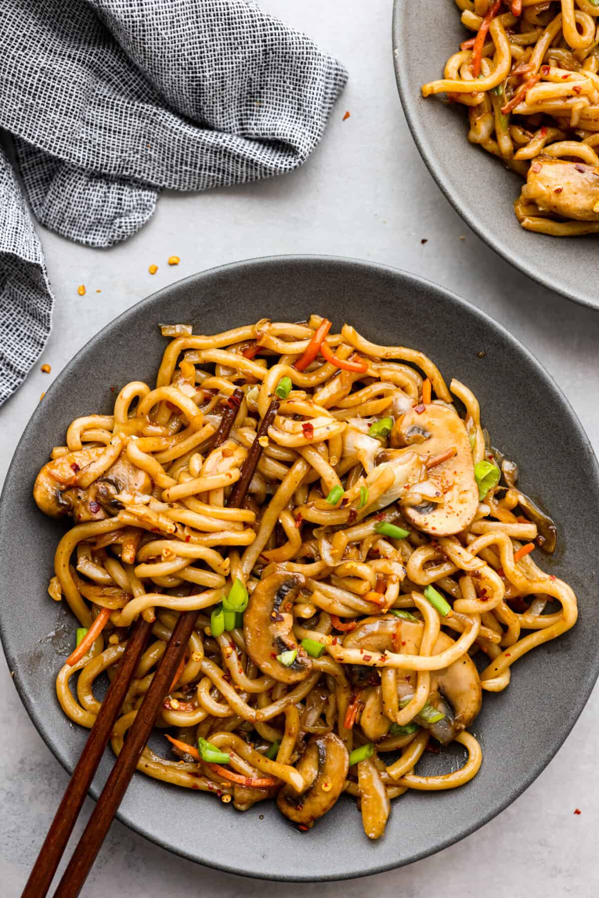 Top view of udon noodles in a gray bowl with chopsticks.