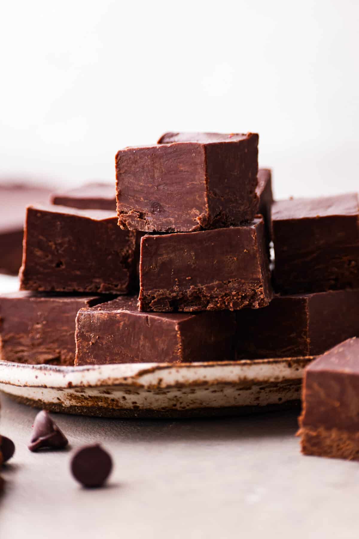 Close view of 2 ingredient fudge pieces stacked on a plate.