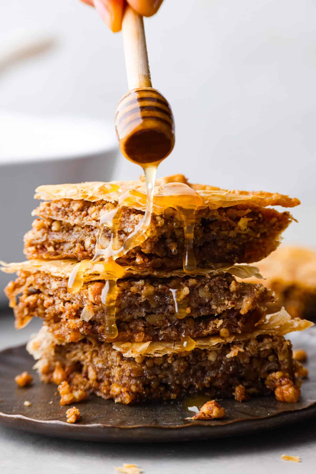 3 pieces of baklava, being coated in honey syrup.