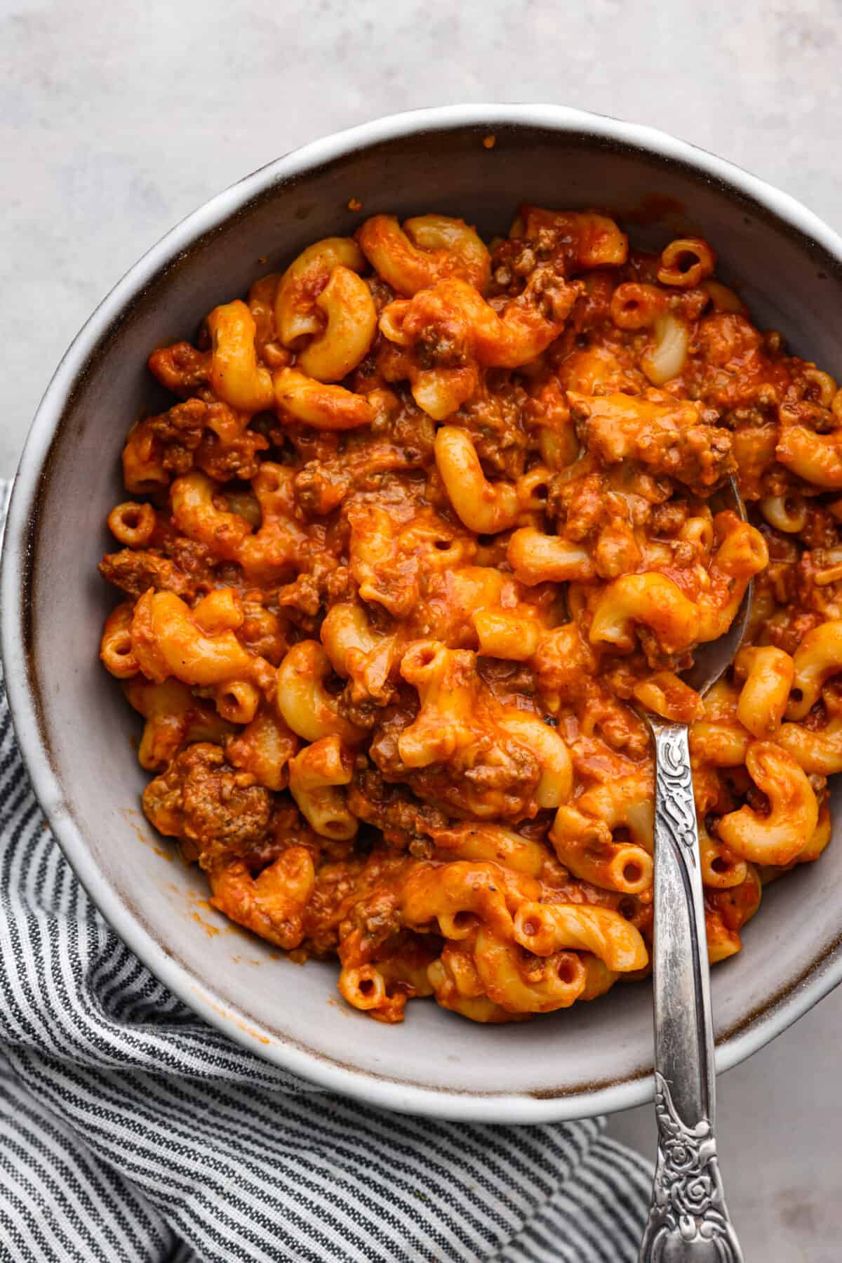 Top-down view of a serving of beefaroni in a gray bowl.