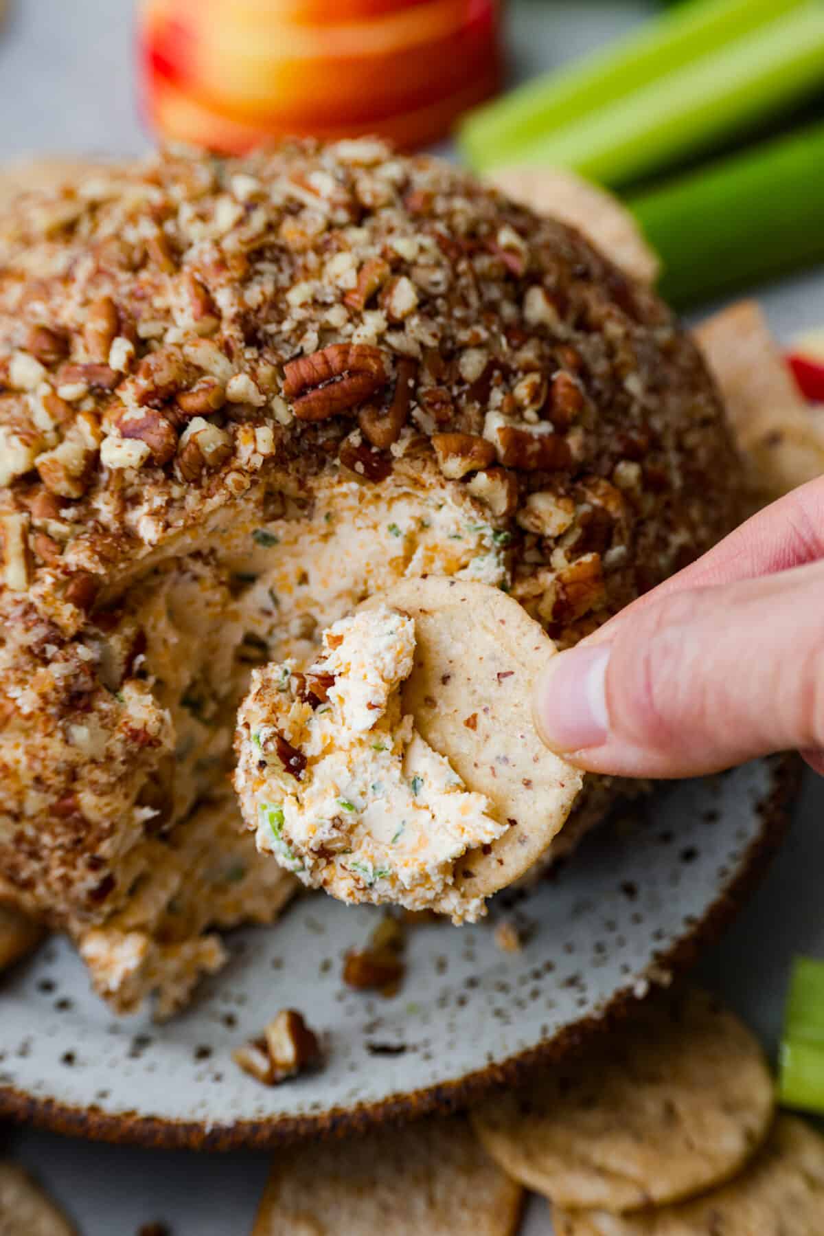 Dipping a cracker into the cheese.