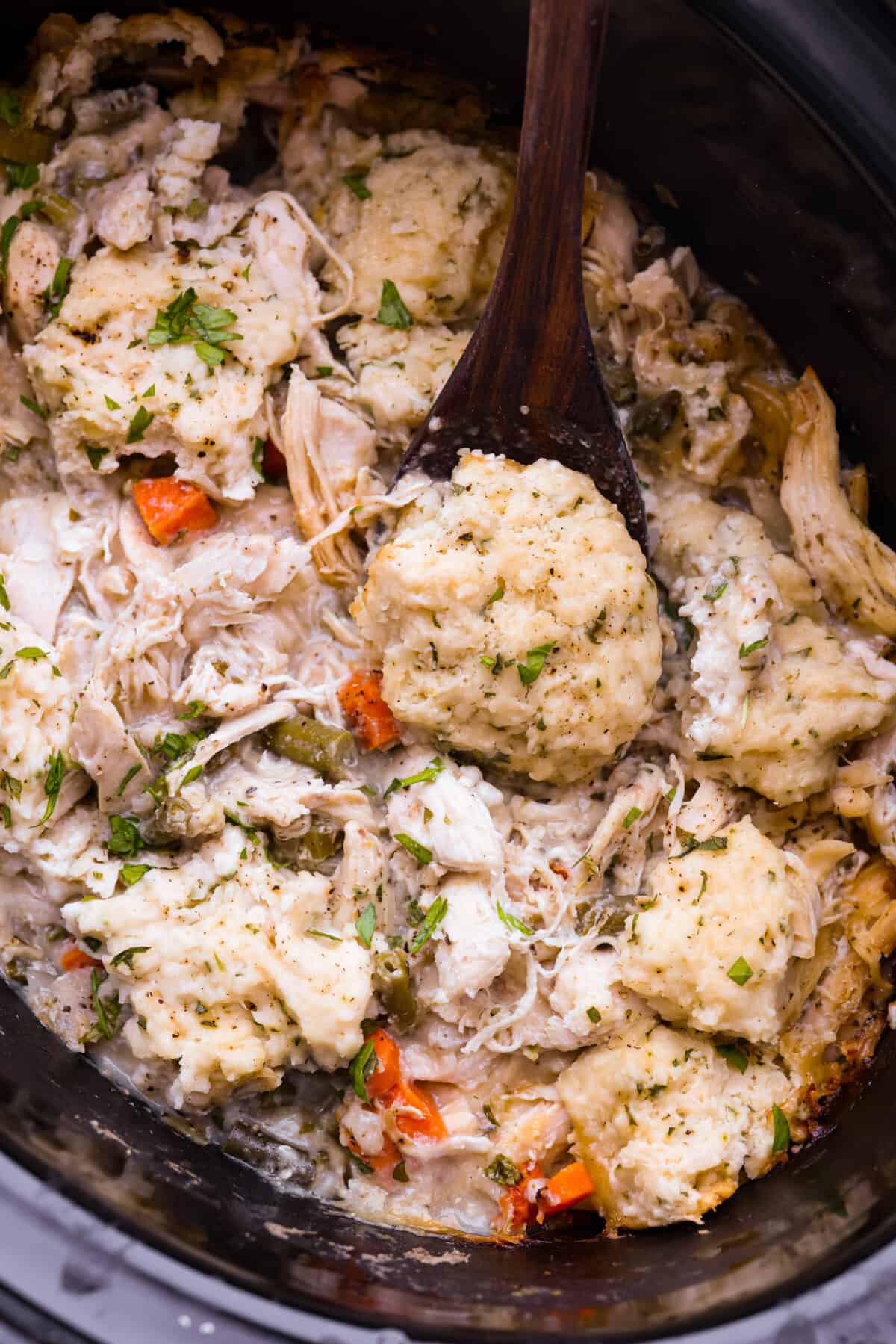 Top view of crockpot chicken and dumplings in a black crockpot.