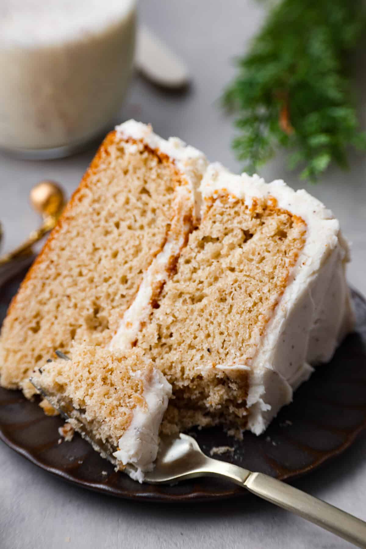 A slice of cake on a plate with a piece of cake on a fork.