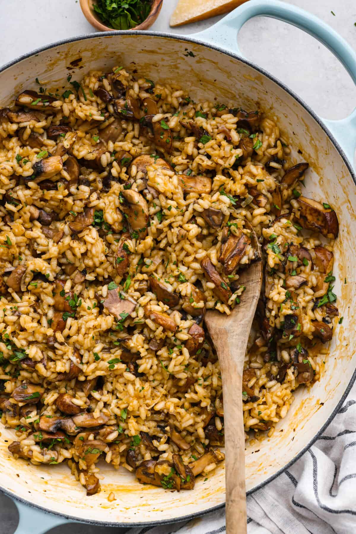 Top-down view of mushroom risotto in a blue and white skillet.