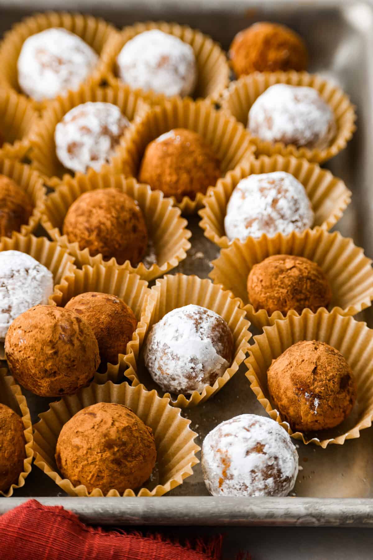 Close side view of rum balls in mini muffin cups.