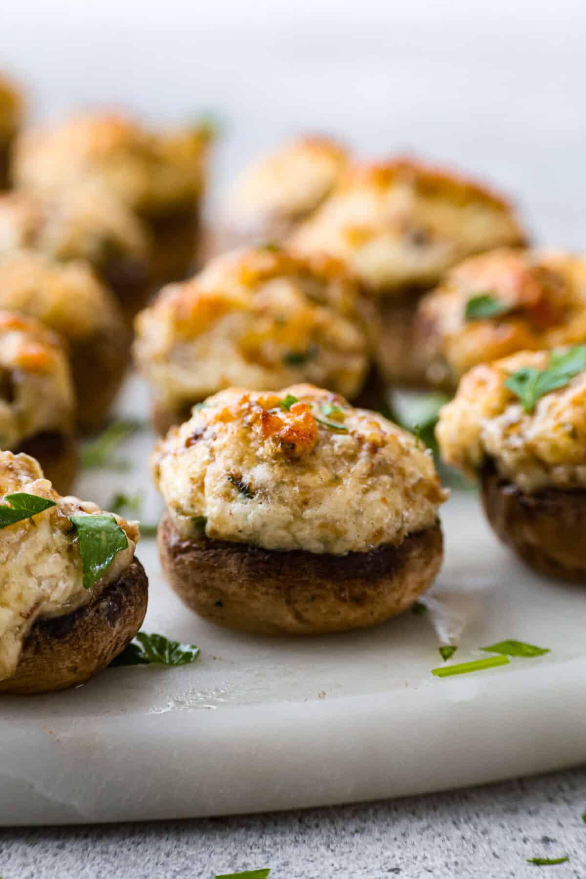 Closeup of a button mushroom filled with a cream cheese and sausage mixture.