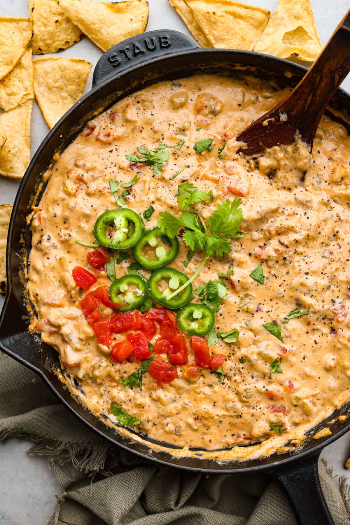 Sausage dip in a black skillet, garnished with chopped jalapenos.