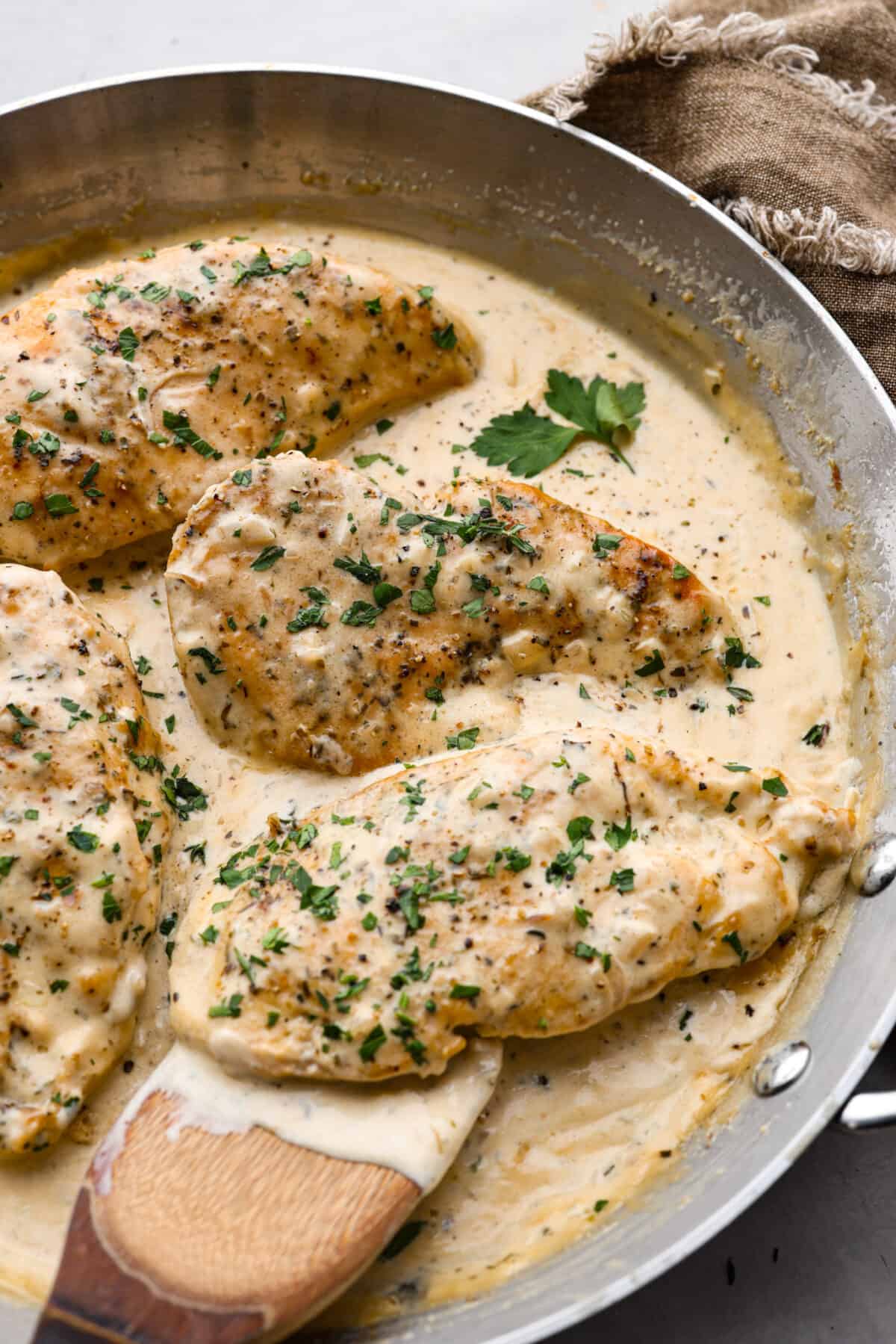 4 pieces of boursin chicken in a metal pan.