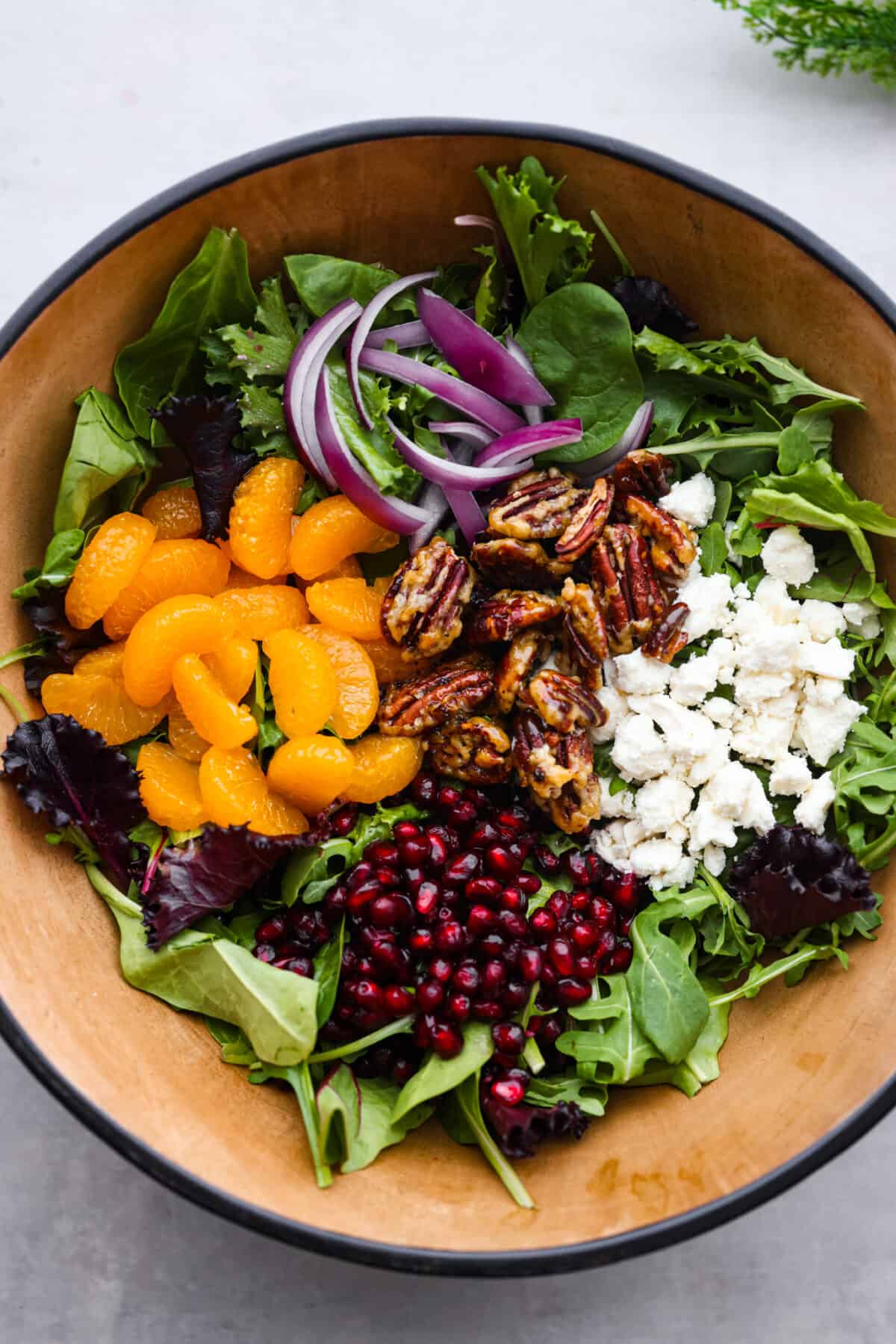 Top view of salad ingredients added to a bowl.