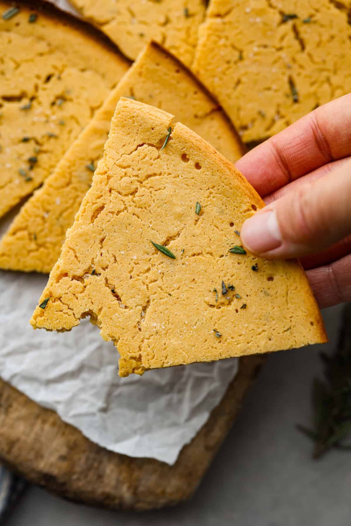 Close view of holding a slice of farinata.