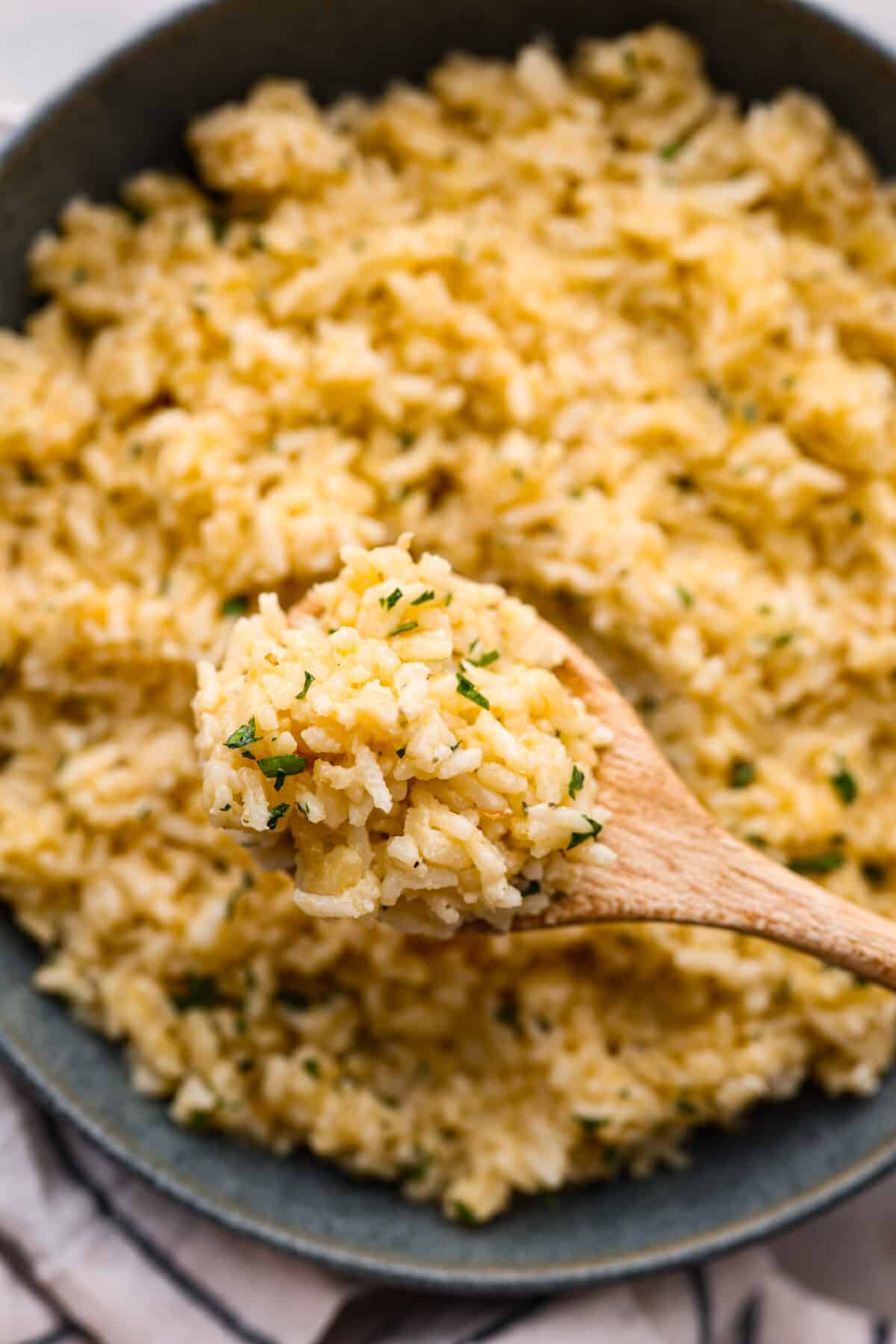 A close up of super rice scooped onto a wooden spoon. 