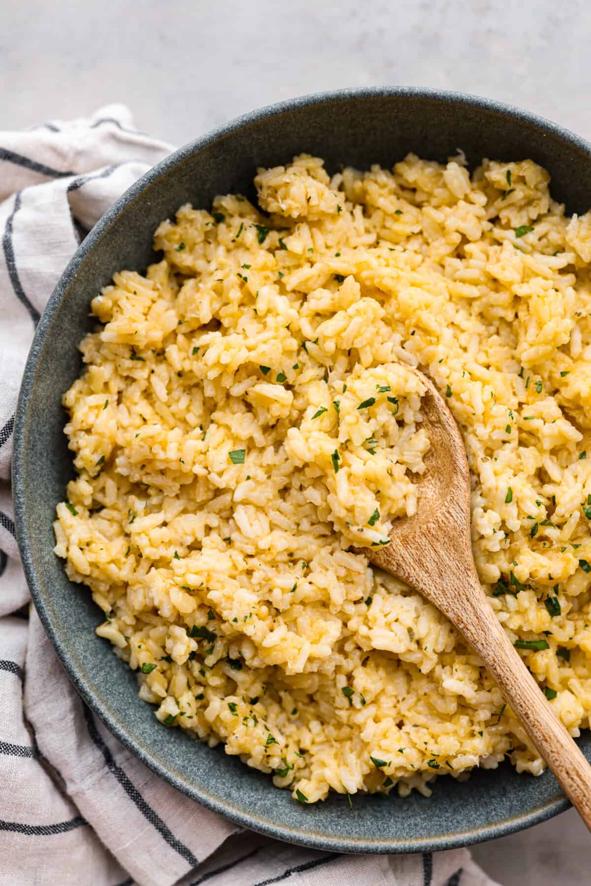 A bowl filled with super rice and a wooden spoon. 