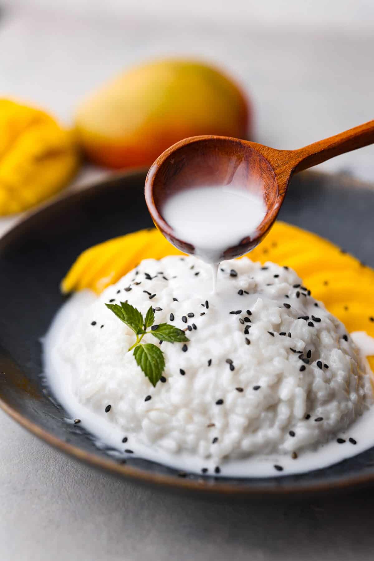 Pouring the coconut sauce over the mango sticky rice.