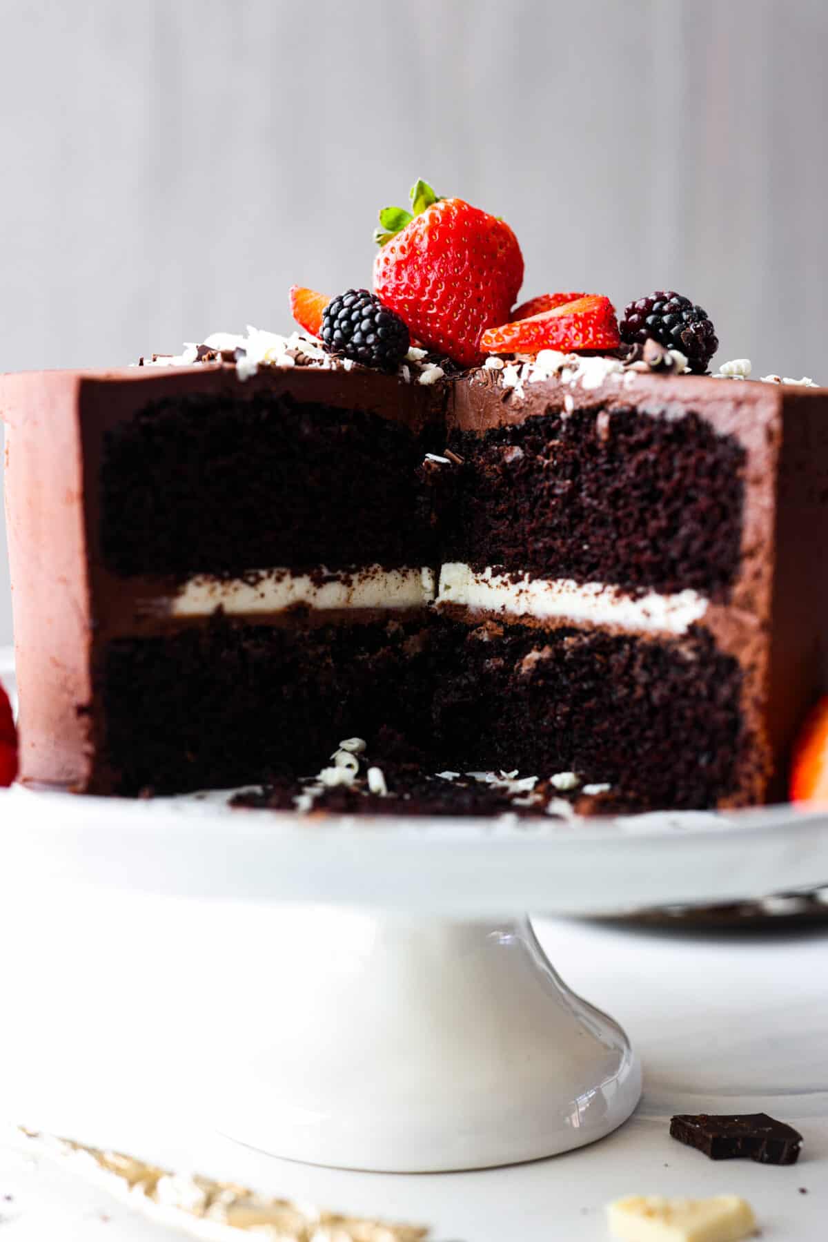 A tuxedo cake with a slice cut out of it. The white chocolate ganache filling on the inside can be seen.