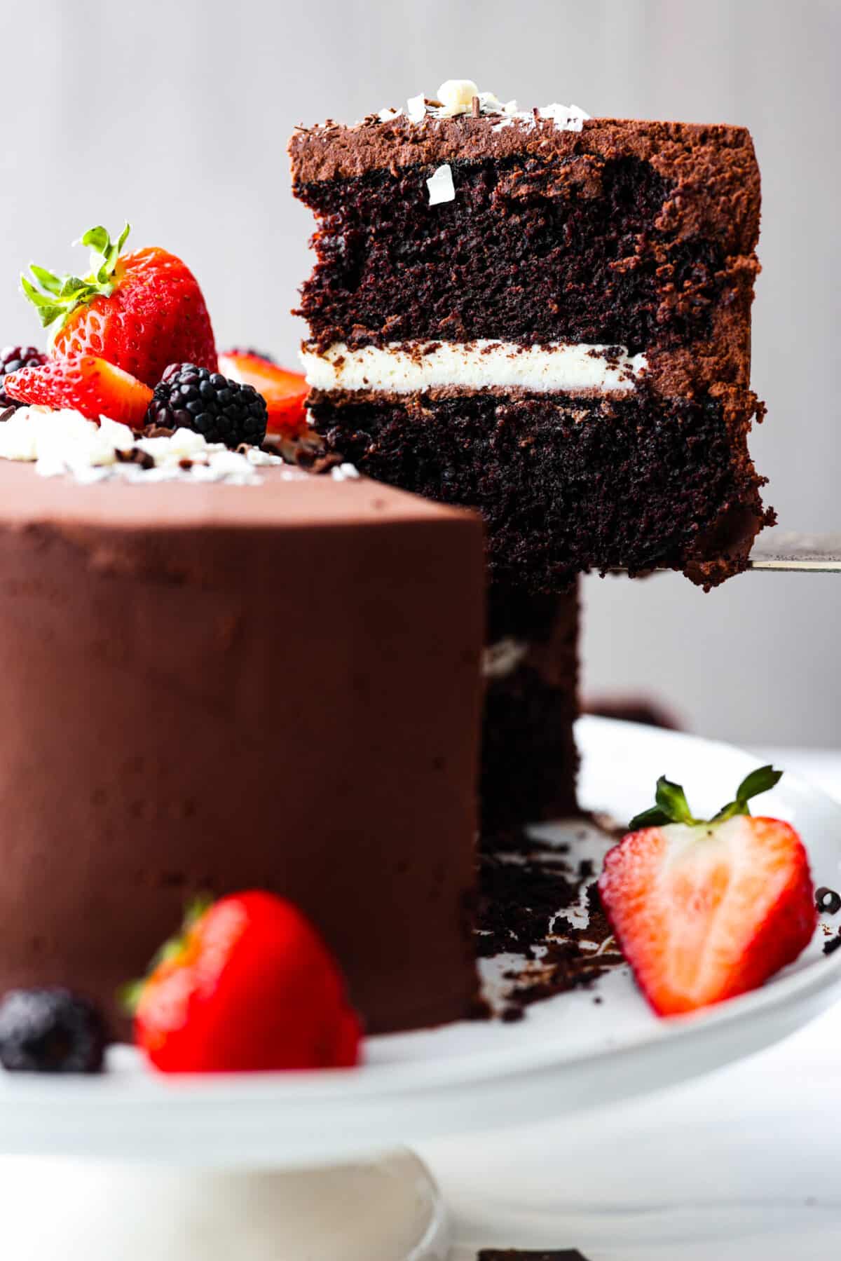 Lifting a slice of tuxedo cake up with a metal spatula.