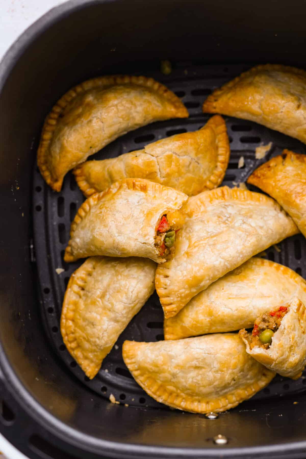 Empanadas in the basket of an air fryer.