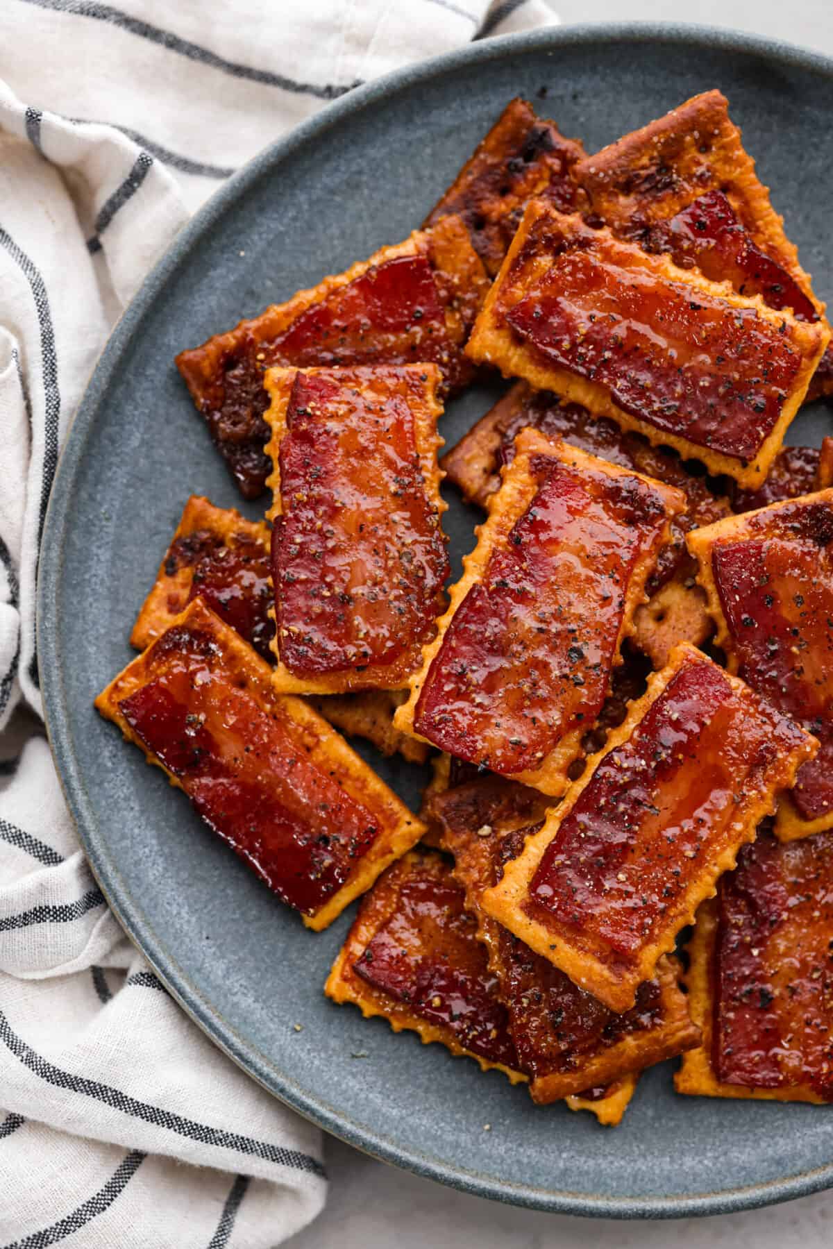 Close top view of bacon crackers stacked on a blue plate.