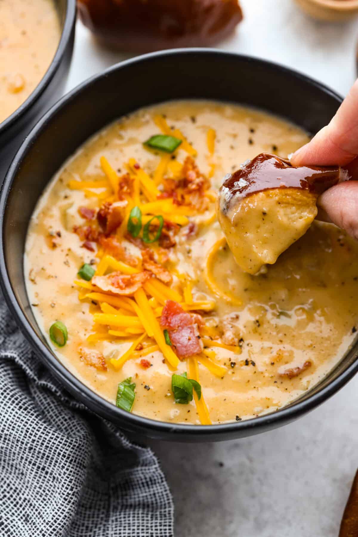 Dipping a pretzel roll into the soup.