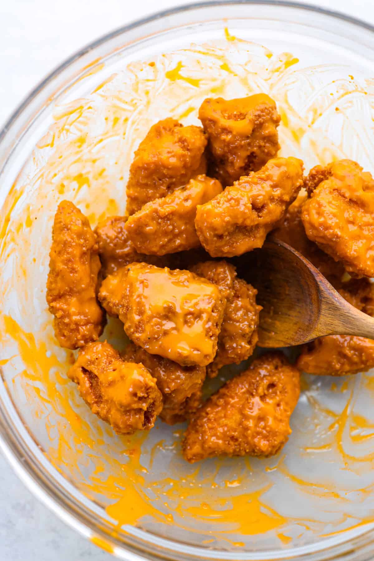 Coating the boneless wings in buffalo sauce.