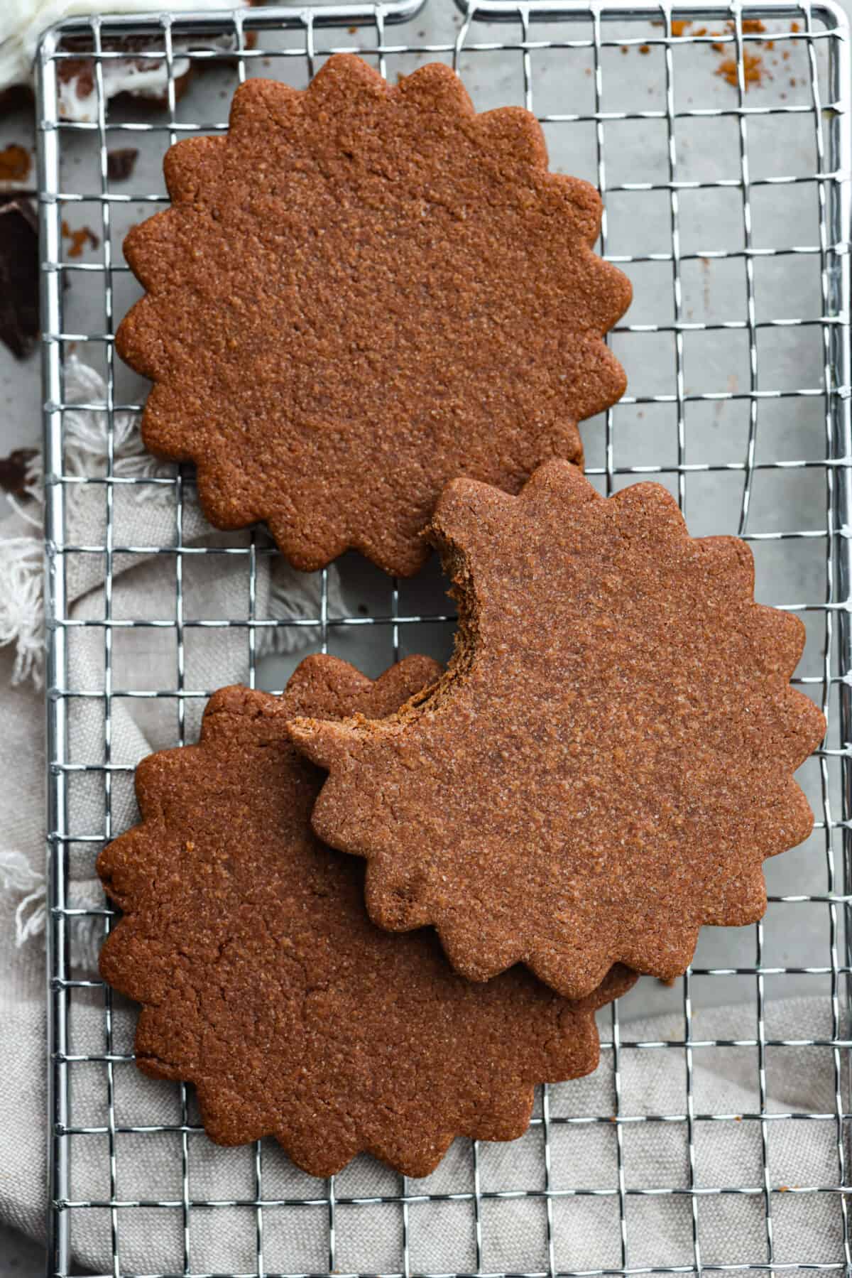 3 cookies on a wire rack. One has a bite taken out of it.