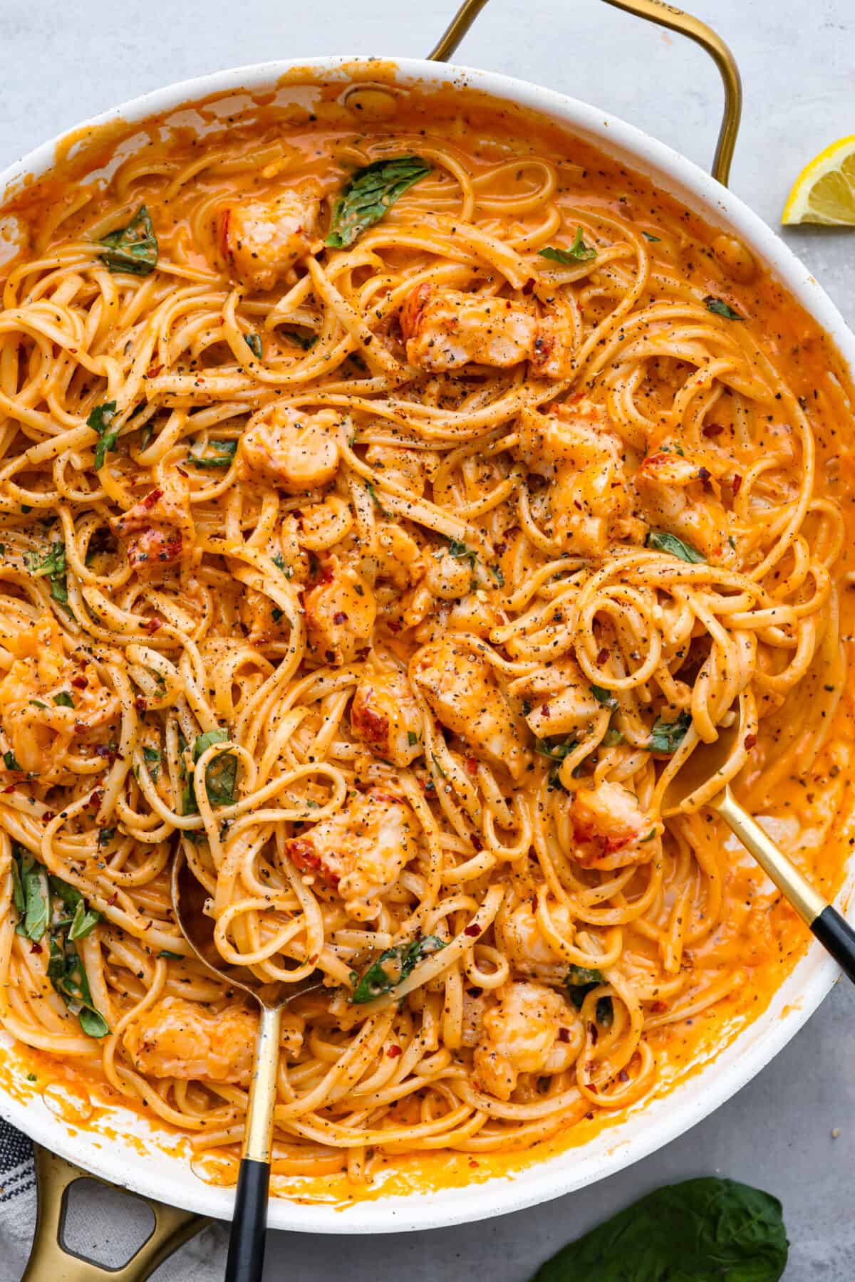 Top-down view of lobster pasta in a white skillet.