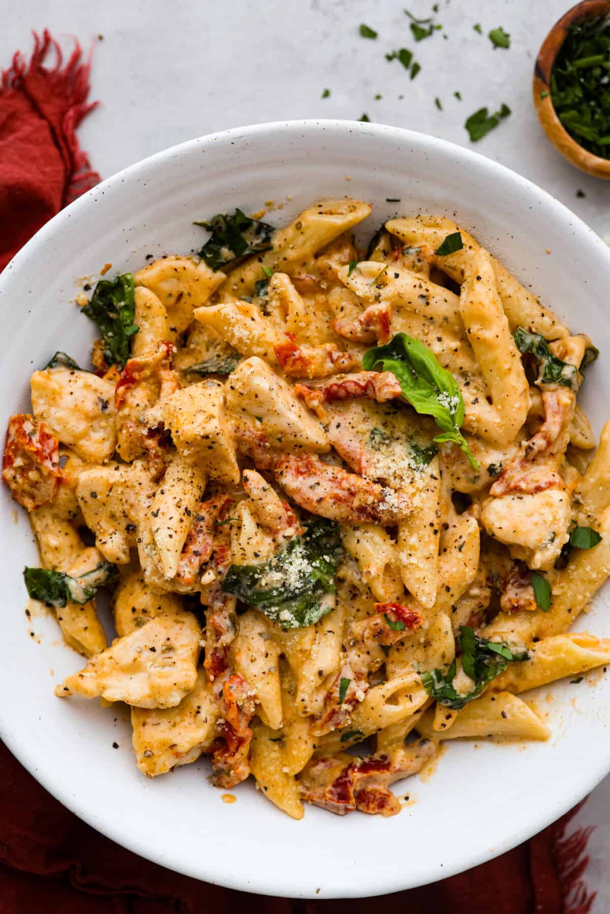 A serving of marry me chicken pasta in a white dish.