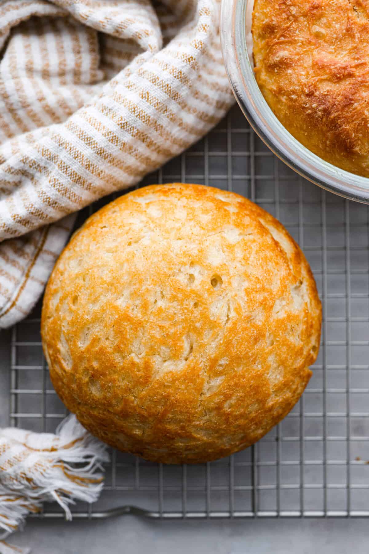 Top view of a loaf of peasant bread on a cooling rack.