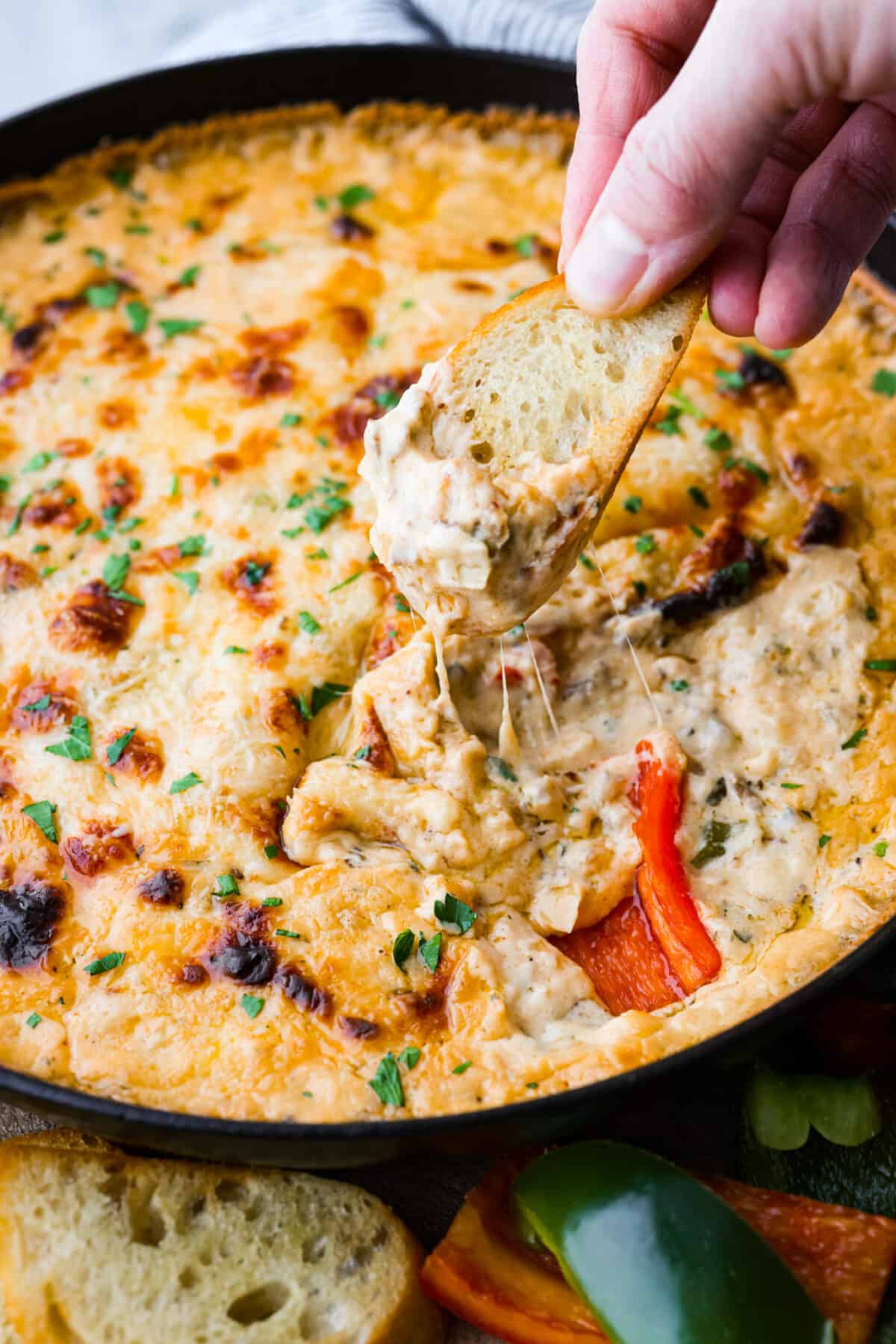 Dipping into the Philly cheesesteak dip with crostini.