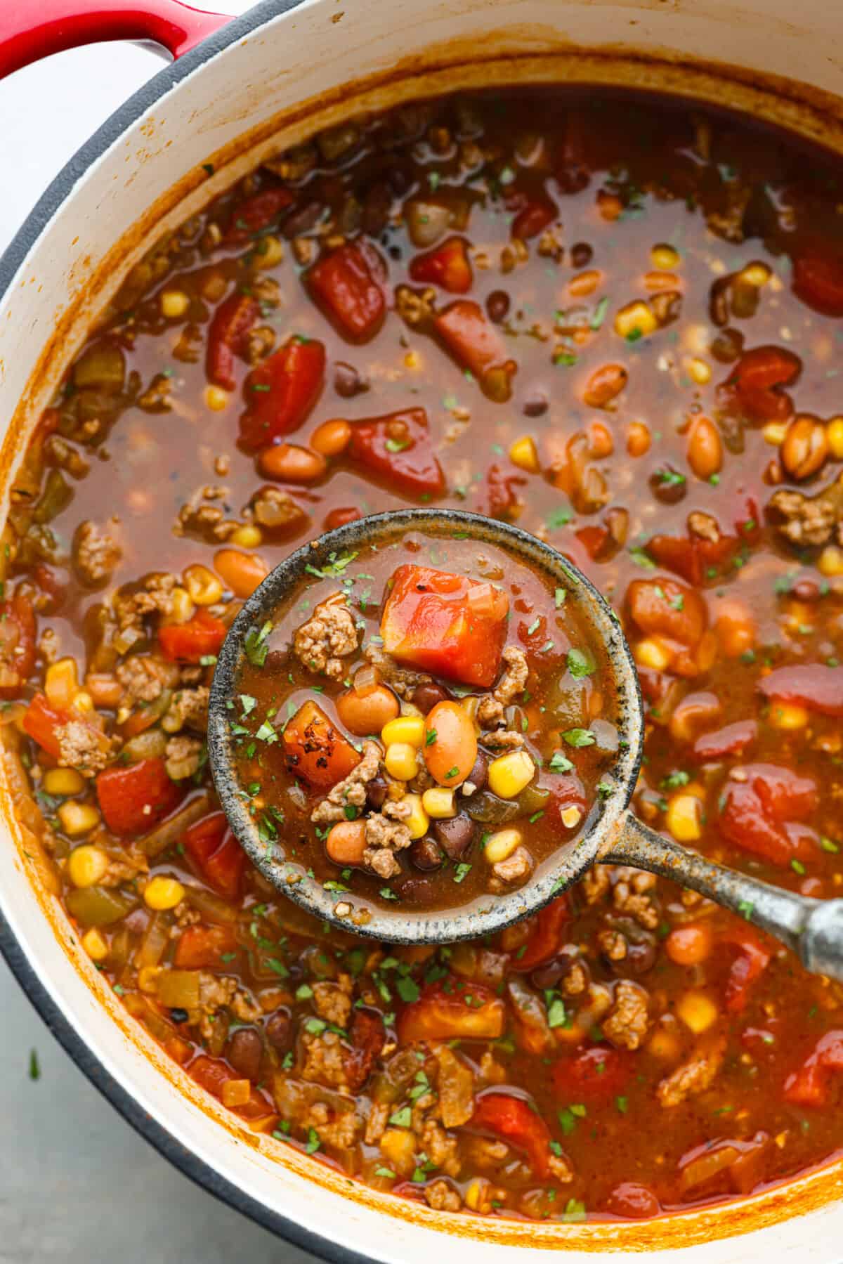 Taco soup being scooped up with a ladle.