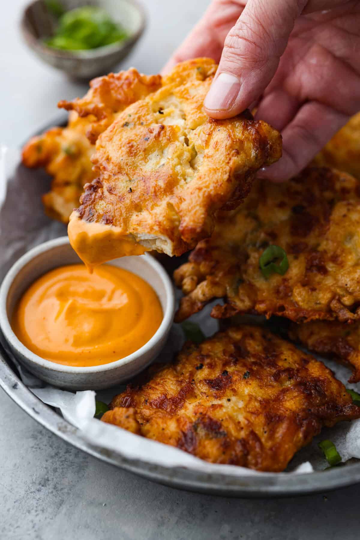 Dipping the chicken into a creamy orange sauce