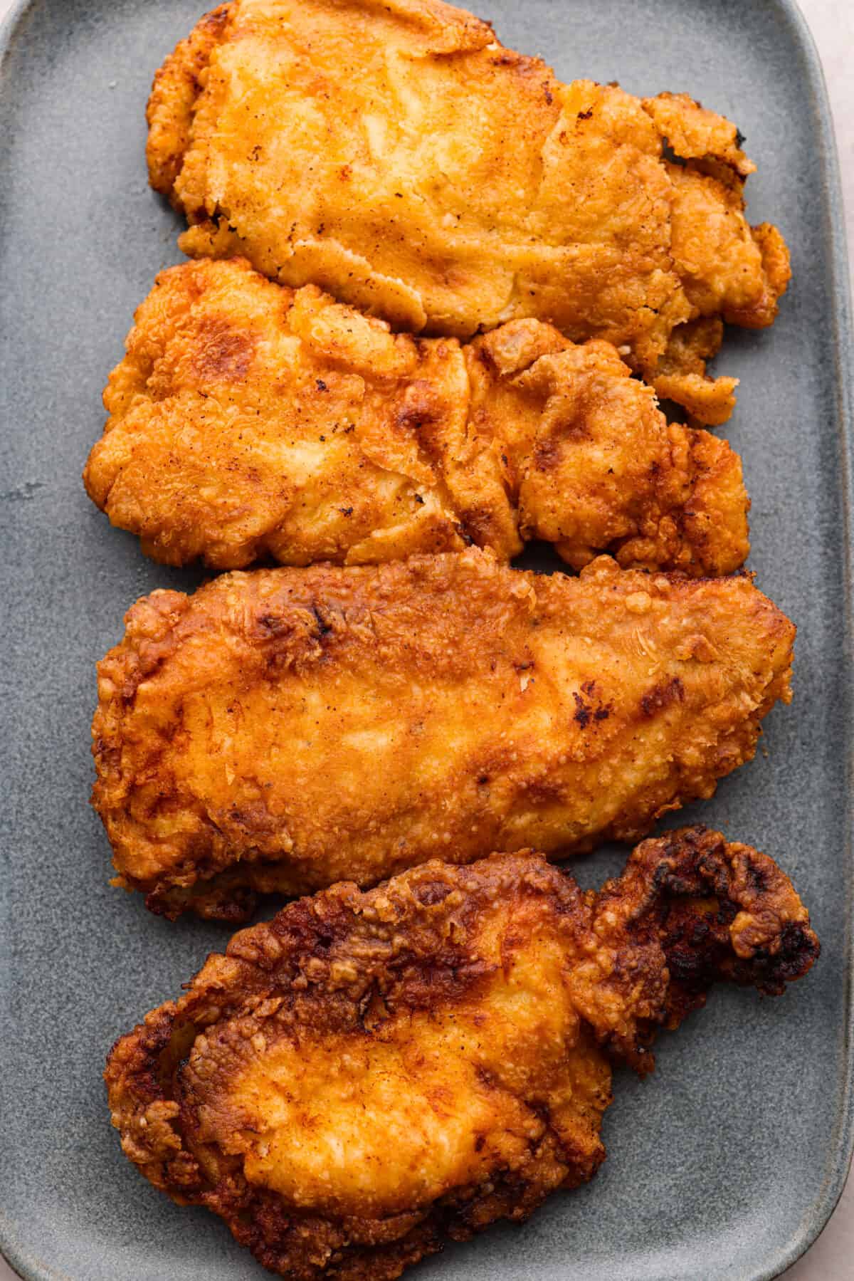 Top-down view of 4 country fried chicken cutlets.