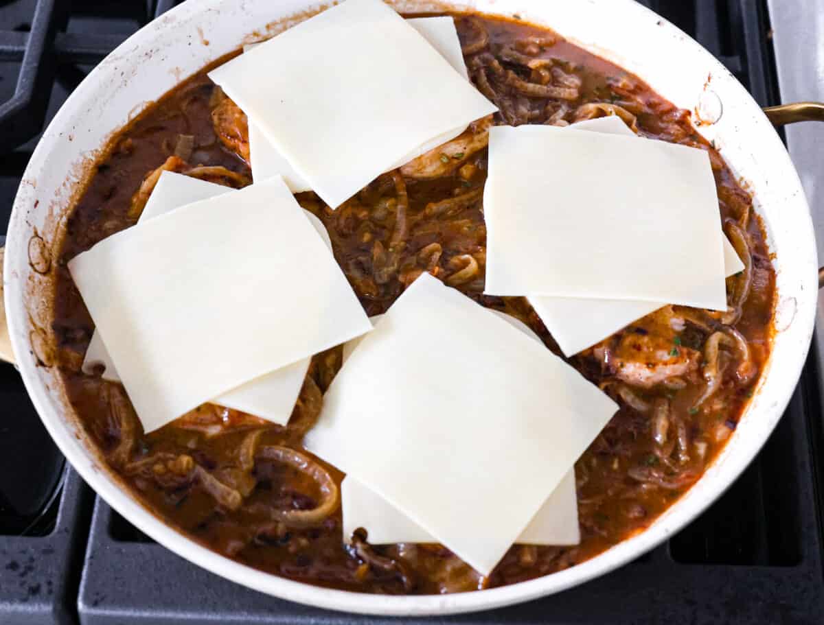 Pork chops topped with cheese slices, before melting