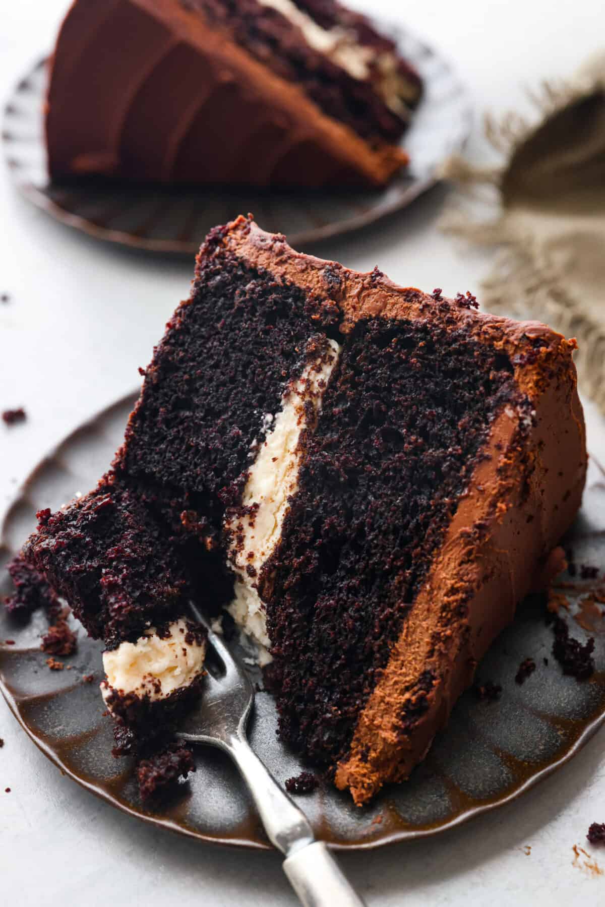 A slice of chocolate Guinness cake on a scalloped plate.