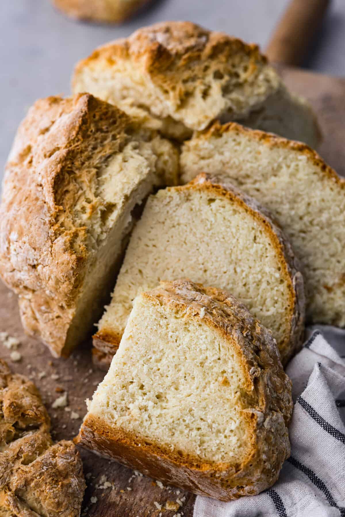 Close view of soda bread cut onto a wood board.