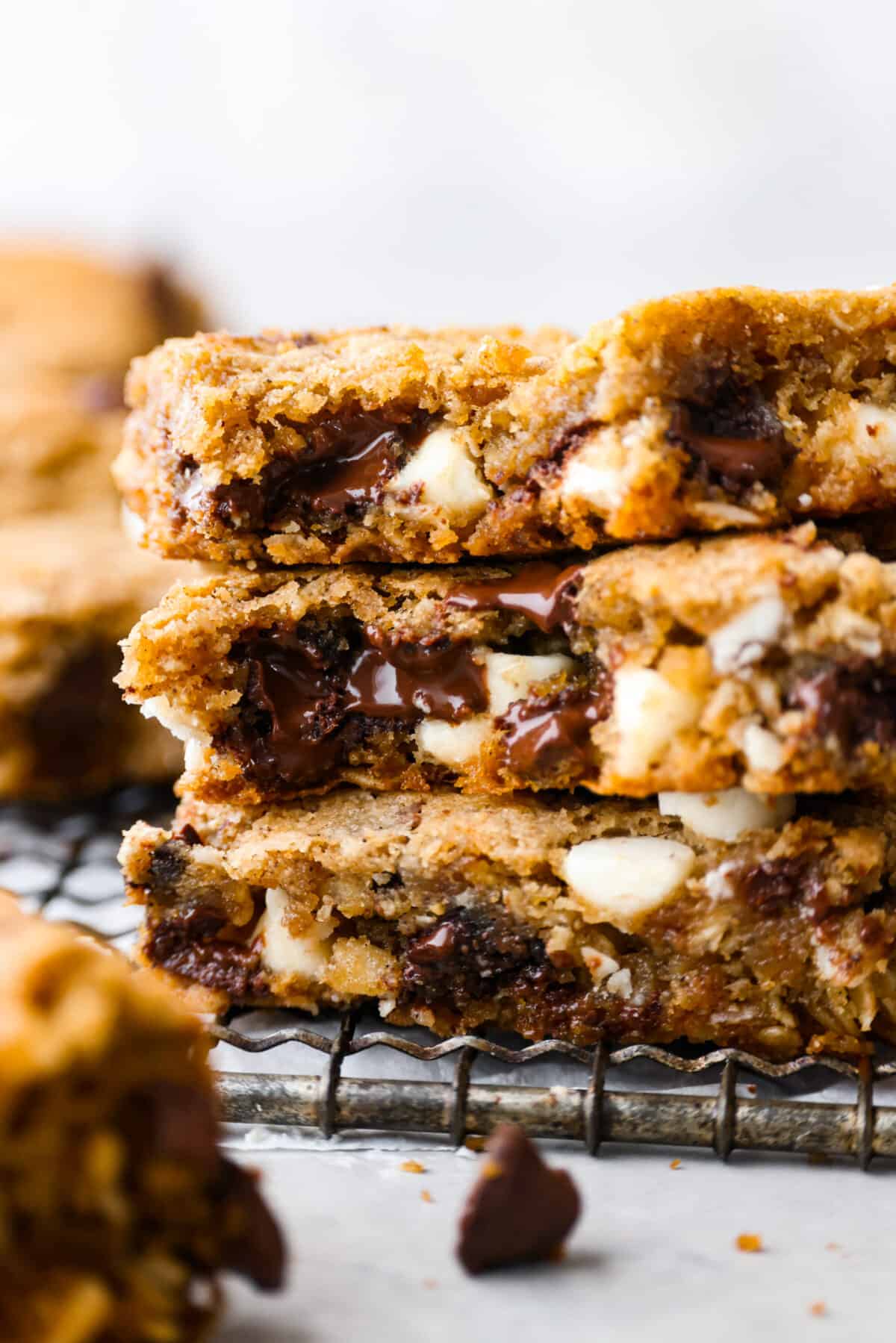 Closeup of 3 cookie bar slices. The melty white and semi sweet chocolate filling can be seen.