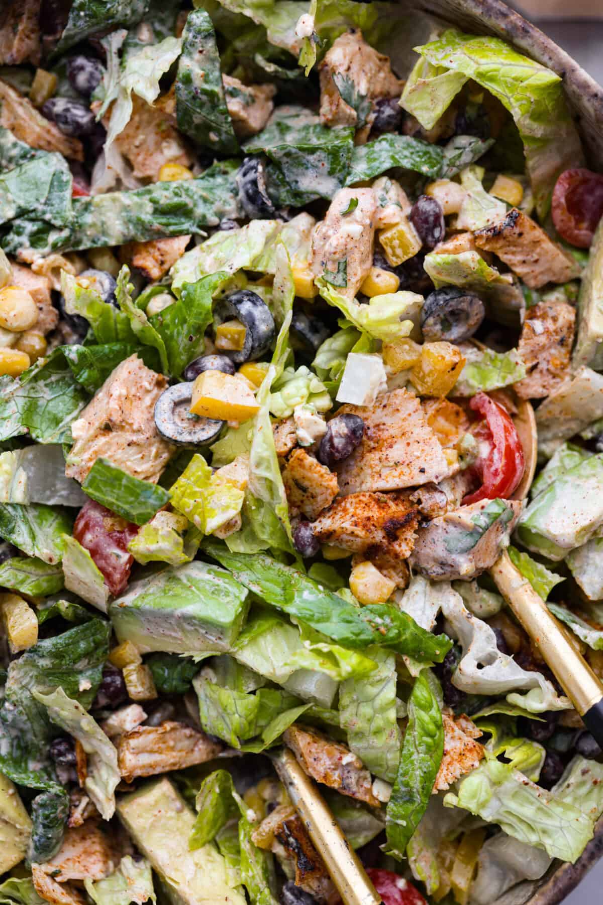 Santa fe salad in a large salad bowl, being tossed.