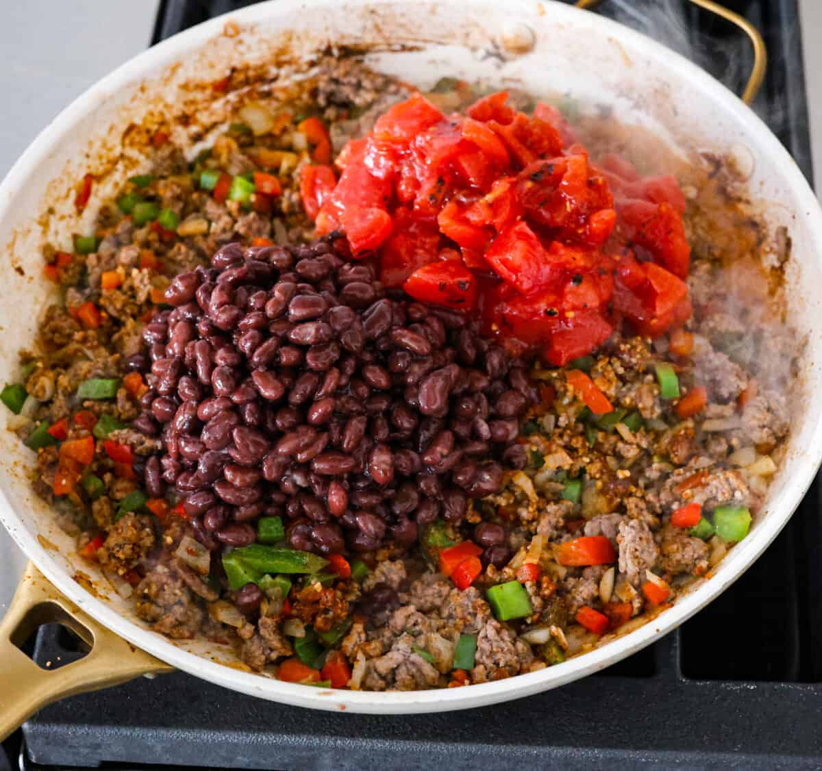 The beans being added to the skillet.