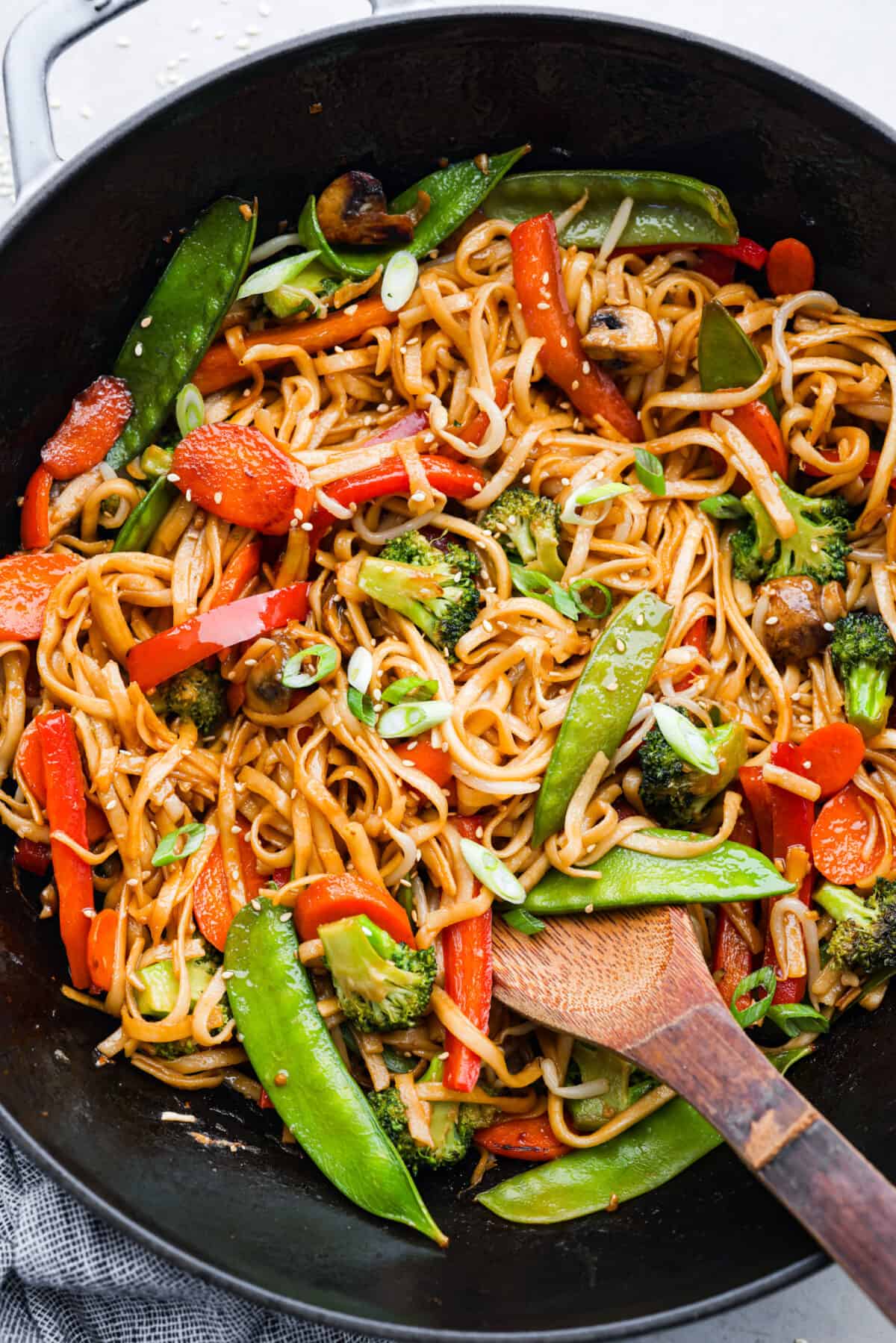 Vegetable lo mein in a black frying pan.