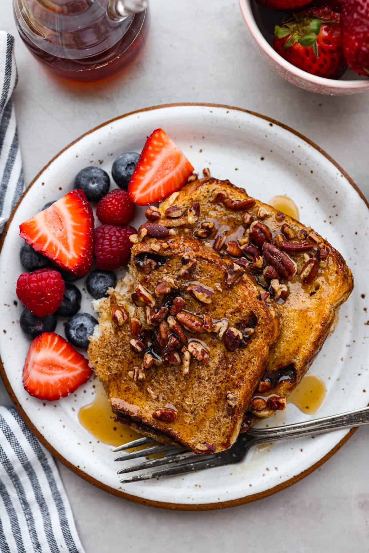 A serving on a stoneware plate, surrounded by fresh berries.