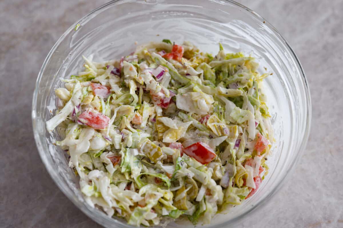 Tossing the vegetables together with the dressing 