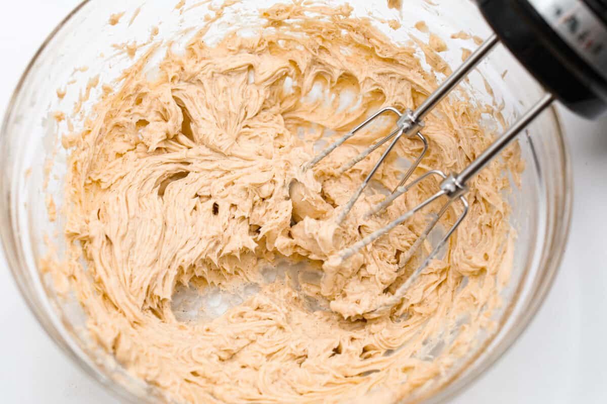 Whipping the butter with a hand mixer.