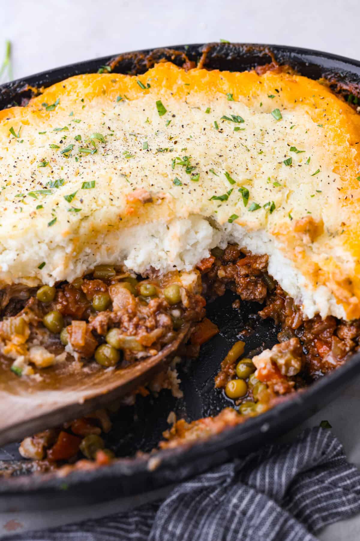 Closeup of Shepherd's pie with a serving taken out of it.