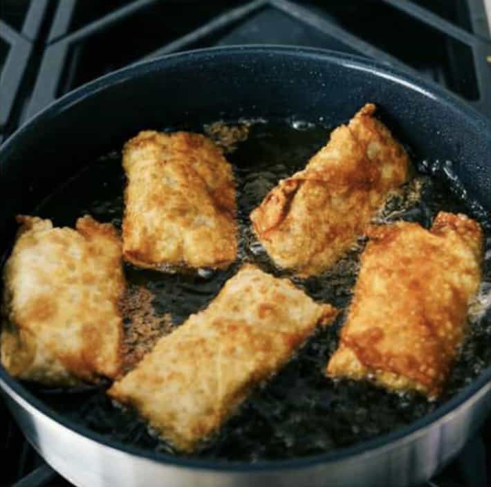 Sixth photo of the egg rolls browned and fried on all sides.